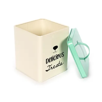 Beżowe metalowe pudełko z czarnym napisem 'Delicious Treats' i zieloną pokrywką, odpowiednie do przechowywania smakołyków dla zwierząt.
