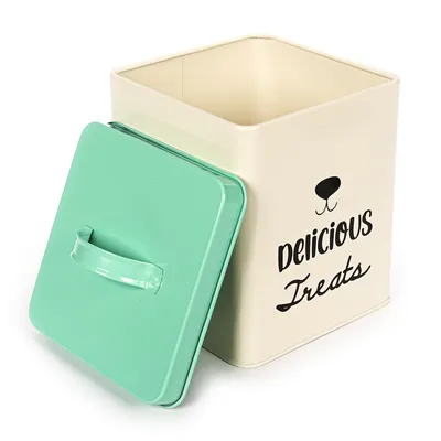 Beżowe metalowe pudełko z zieloną pokrywką i czarnym napisem 'Delicious Treats', odpowiednie do przechowywania smakołyków.