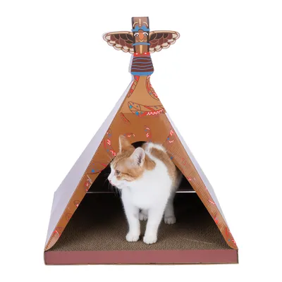 Chat blanc et roux dans une tente en carton décorée de motifs colorés, sol en carton ondulé, ornement en forme de totem sur le dessus.