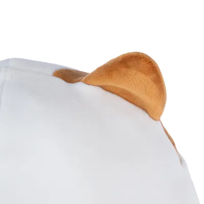 Detailní záběr na bílý plyšový polštář s hnědýma ušima, vhodný pro dekoraci nebo pohodlí.