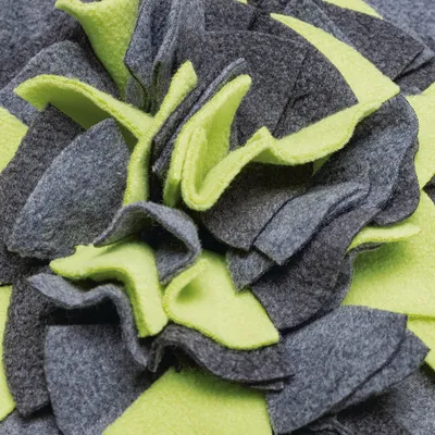 Detailaufnahme eines Spielzeugs aus grauem und gelbem Filzmaterial, geeignet für interaktives Spielen oder Schnüffelaktivitäten.