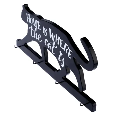Llavero negro con forma de gato y texto blanco: 'Home is where the cat is'.