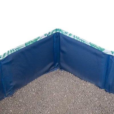 Osłona narożna z niebieskiego tworzywa sztucznego z wzorem liści na górze, wypełniona szarym żwirkiem. Ochrona narożników przed zabrudzeniem żwirkiem dla zwierząt.