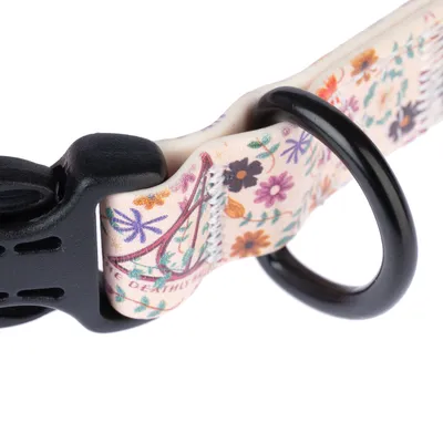 Nahaufnahme eines Halsbands mit floralem Muster, schwarzer Kunststoffverschluss und Metallring.