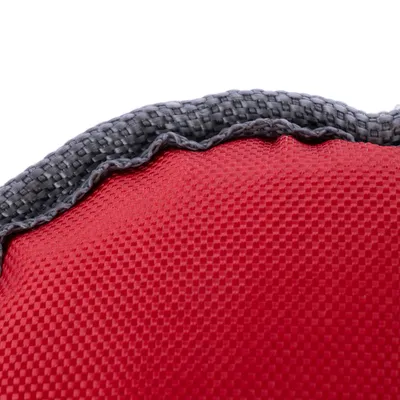 Nærbillede af rødt, struktureret stofmateriale med grå kant af vævet materiale.
