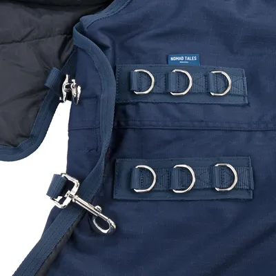 Nomad Tales hondentuig in donkerblauw met meerdere metalen ringen en stevige gespen voor veilige bevestiging.