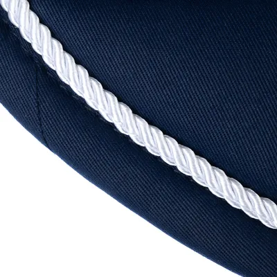 Nahaufnahme eines dunkelblauen Stoffmaterials mit weisser gedrehter Kordel als dekoratives Detail.