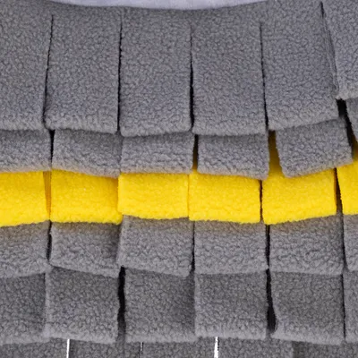 Vista dettagliata di materiale in pile grigio e giallo con frange sovrapposte, adatto per accessori o giocattoli per animali.