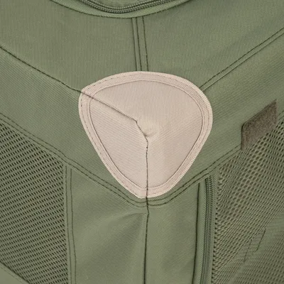 Vista detallada de un bolso de transporte verde con malla y refuerzo de tela en beige.