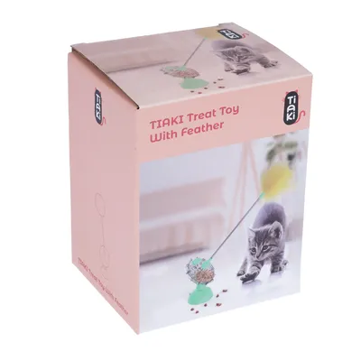 Pakiranje Tiaki Treat Toy with Feather, prikazuje igračku sa zelenom bazom i žutim perom te mačku koja se igra. Tekst: 'Tiaki Treat Toy With Feather'.