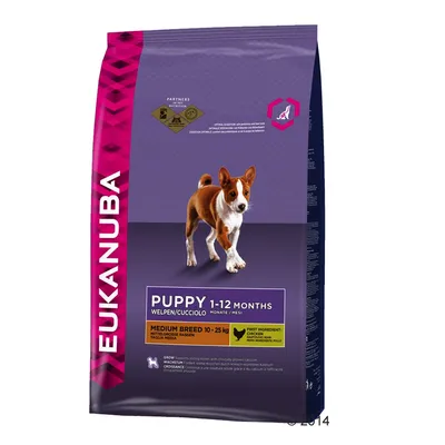 Saco de ração Eukanuba Puppy 1–12 Months para cães de raça média 10–25 kg. Indicação: primeiro ingrediente frango. Texto em inglês, alemão, italiano e espanhol visível.