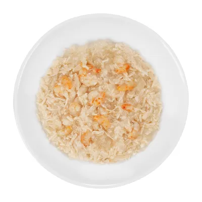 Assiette blanche contenant de la nourriture humide pour animaux, avec morceaux visibles de crevettes et viande effilochée dans une sauce claire. Aucun emballage ou texte visible.