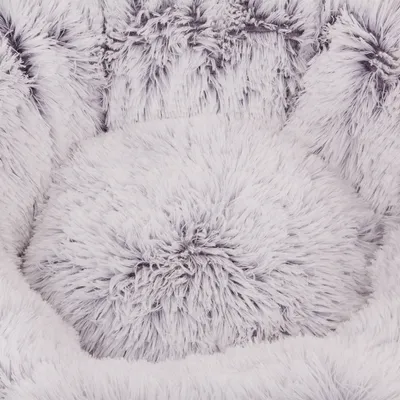 Close-up de um material branco felpudo com fibras longas, possivelmente adequado para cama ou almofada para animais de estimação.