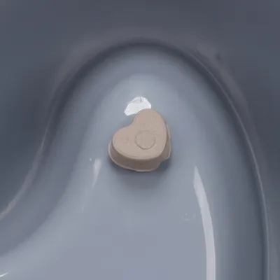 Srdčité tableta na hladkém modrém povrchu. Detailní záběr produktu.