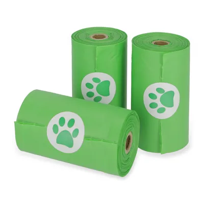Trois rouleaux de sacs verts en plastique avec motif patte d’animal visible sur chaque rouleau. Aucun texte ou marque n’est affiché.