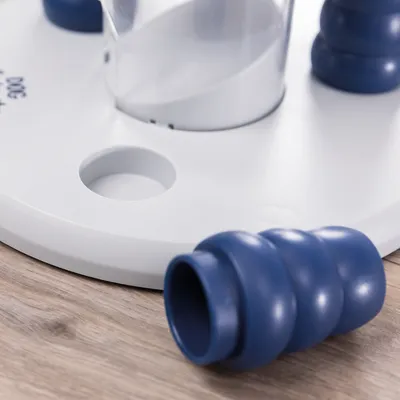 Close-up of a white game board with blue plastic elements and a transparent container. Suitable for interactive play or training.