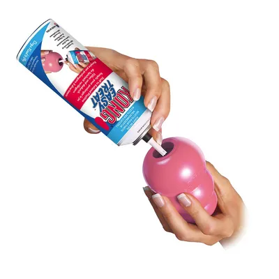 Anwendung von Kong Easy Treat: Creme aus der Dose wird in ein rosafarbenes Kong-Spielzeug gefüllt.