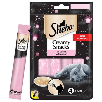 Sheba Creamy Snacks mit Lachs au Saumon, 4 x 12 g annospakkaus, vaaleanpunaiset tuubit, harmaa kissa, NEU NOUVEAU -merkintä, annoskuva. Näkyvä teksti saksaksi ja ranskaksi.