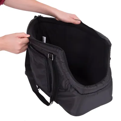 Sac de transport noir pour animaux, avec bandoulière réglable, poche zippée sur le côté et intérieur rembourré. Deux mains tiennent le sac ouvert.