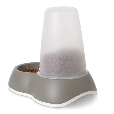Automatische voerdispenser van grijs plastic met transparant reservoir gevuld met droogvoer, naast een geïntegreerde voerbak.