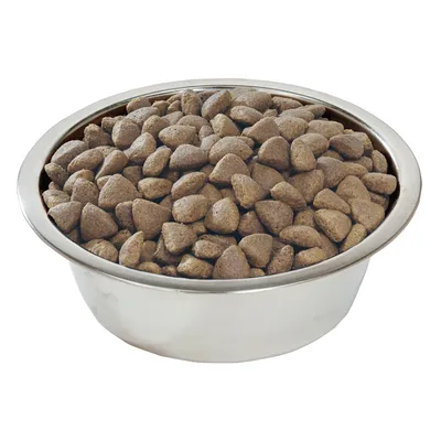 Метална купа, пълна със суха храна за домашни любимци с кафяви гранули. Видими са формата и текстурата на храната.