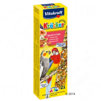 Vitakraft Kräcker Original, migdały i figi, 2 sztuki. Opakowanie z wizerunkiem papug, napisami: SUGAR FREE RECIPE, VITALITY PLUS, VITAMINE. Widoczne mieszanki ziaren na patyku.