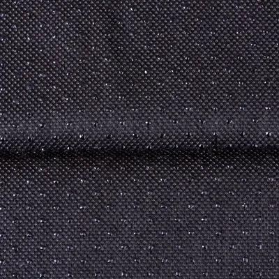 Gros plan sur un tissu noir à texture antidérapante avec petits points en relief, matière synthétique visible.