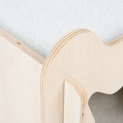Detailní pohled na světlý dřevěný rám se zakřiveným designem a bílým měkkým polstrováním.