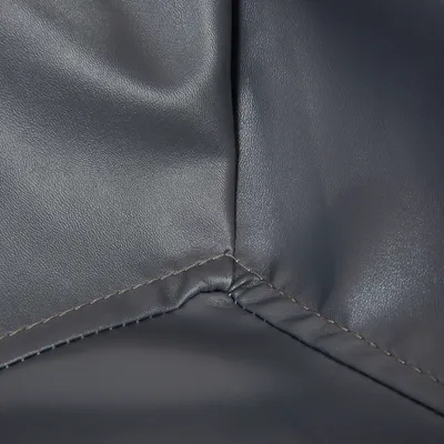 Nahaufnahme einer grauen Lederoberfläche mit sichtbaren Nähten.