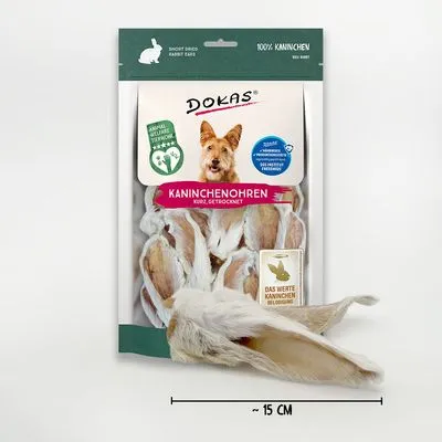 DOKAS Kaninchenohren, kurz, gedroogd. Verpakking met afbeelding van hond en zichtbare konijnenoren. Tekst: 100% Kaninchen, Das wertet Kaninchen vollständig biologisch. Lengte ~15 cm.
