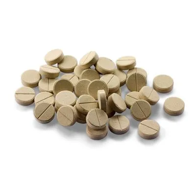 Stapeltje ronde, lichtbruine tabletten met breuklijn, geen merknaam of tekst zichtbaar.