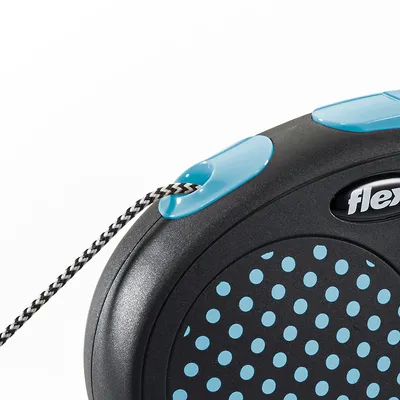 Guinzaglio avvolgibile Flexi, parte del manico nero con pois azzurri e dettagli blu, corda intrecciata bianca e nera visibile.