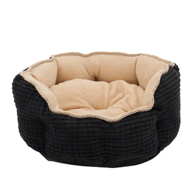 Rundt, polstret kæledyrsbed med sort vaffelmønster udvendigt og beige fleece indvendigt.