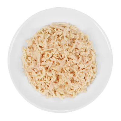 Hvid skål med strimlet, lyst kød i sauce, set oppefra. Ingen synlige mærker eller tekst.