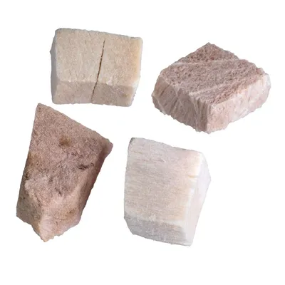 Quattro cubetti di snack per animali, colore beige e marrone chiaro, superficie porosa, senza confezione visibile o marchio.