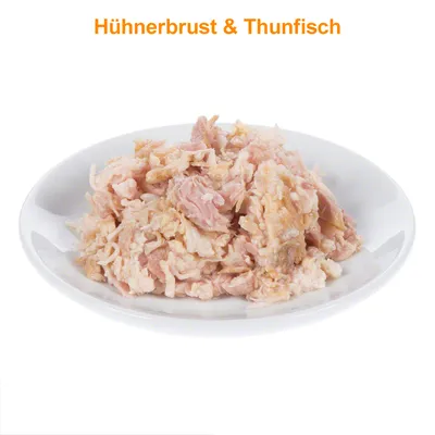 Pileća prsa i tuna (Hühnerbrust & Thunfisch) na bijelom tanjuru, vidljivi komadi mesa. Tekst na slici je na njemačkom jeziku.