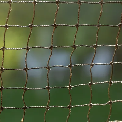 Primer plano de una red marrón con mallas cuadradas, adecuada para varios usos en exteriores.