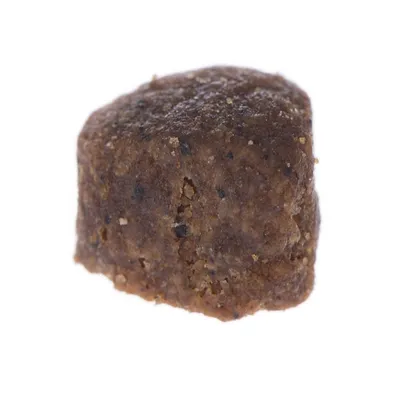 Närbild på ett brunt, fyrkantigt foder- eller godisbitar utan synlig text eller varumärke.