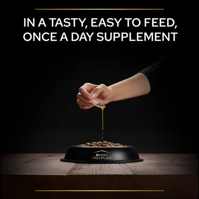 Hand pouring liquid supplement over kibble in a Purina Pro Plan bowl. Text: In a tasty, easy to feed, once a day supplement.
