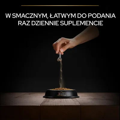Ręka posypuje karmę w misce Purina Pro Plan proszkiem z miarki. Widoczny tekst: W smacznym, łatwym do podania raz dziennie suplemencie.