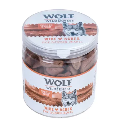 Wolf of Wilderness Wide Acres 100% Chicken Hearts, Freeze Dried -kanaa sisältävä purkki, etiketeissä susikuva ja tuoteteksti näkyvissä.