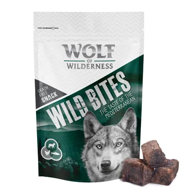 Sachet Wolf of Wilderness Wild Bites, texte visible : Grain Free Snack, The Taste of the Mediterranean. Trois cubes de friandises bruns devant l’emballage.