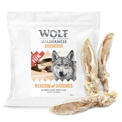 Wolf of Wilderness Wild Chews Meadow Grounds, Rabbit Ears with Fur, gently air dried, 400 g. Förpackning och två torkade kaninöron med päls synliga.