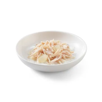 Schüssel mit zerkleinertem Hühnerfleisch und Stückchen in heller Sosse, serviert als Nassfutter.