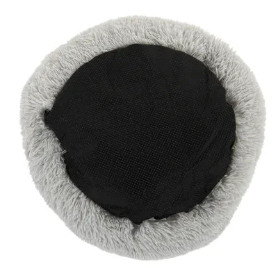 Vue du dessous d’un coussin rond pour animal, centre en tissu noir antidérapant, bordure en fausse fourrure grise.
