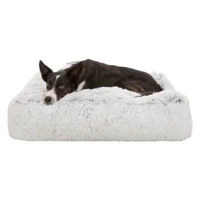 Panier pour chien en tissu peluche gris clair, chien noir et blanc couché dessus, fond blanc.