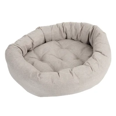 Letto per animali rotondo e imbottito in tessuto beige con bordo morbido e interno trapuntato.