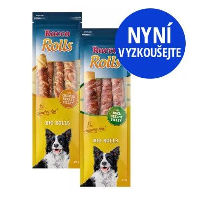 Dva balíčky Rocco Rolls Big Rolls: Chicken Breast Fillet a Duck Breast Fillet, nápis 'NYNÍ VYZKOUŠEJTE' v modrém kruhu, obrázek psa na obalu.