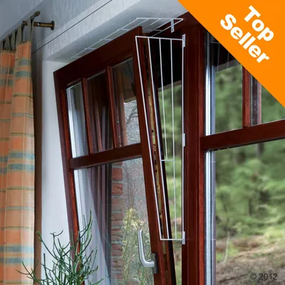 Grille de sécurité en métal blanc installée sur une fenêtre basculante en bois. Bande orange en haut à droite avec texte anglais : Top Seller. Grille de sécurité en métal blanc installée sur une fenêtre basculante en bois. Bande orange en haut à droite avec texte anglais : Top Seller.