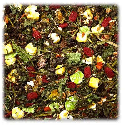 Close-up of mixed dried pet food containing green leaves, red pellets, yellow corn pieces, seeds and various plant ingredients.
